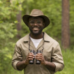 medium-shot-smiley-man-wearing-binoculars (1)